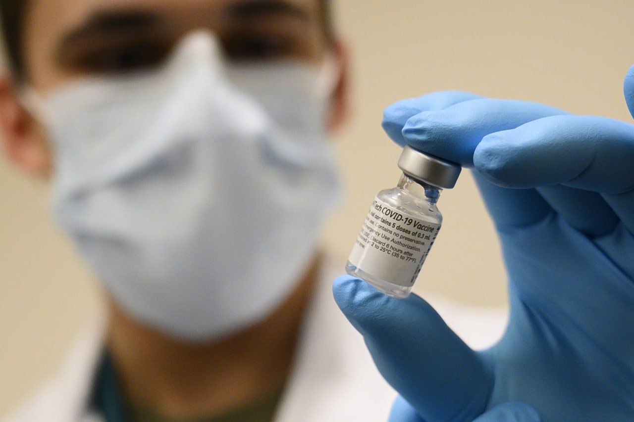 scientist holding pfizer biontech vaccine