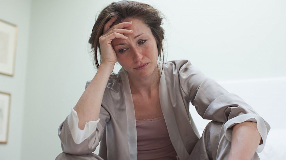 woman thinking about cost of biden gas prices, looking concerned
