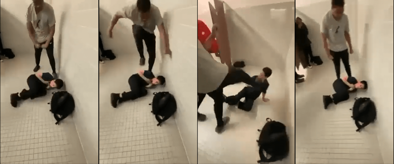 young white boy wearing dark shirt is thrown into concrete wall and stomped by larger black student wearing grey shirt in public school bathroom